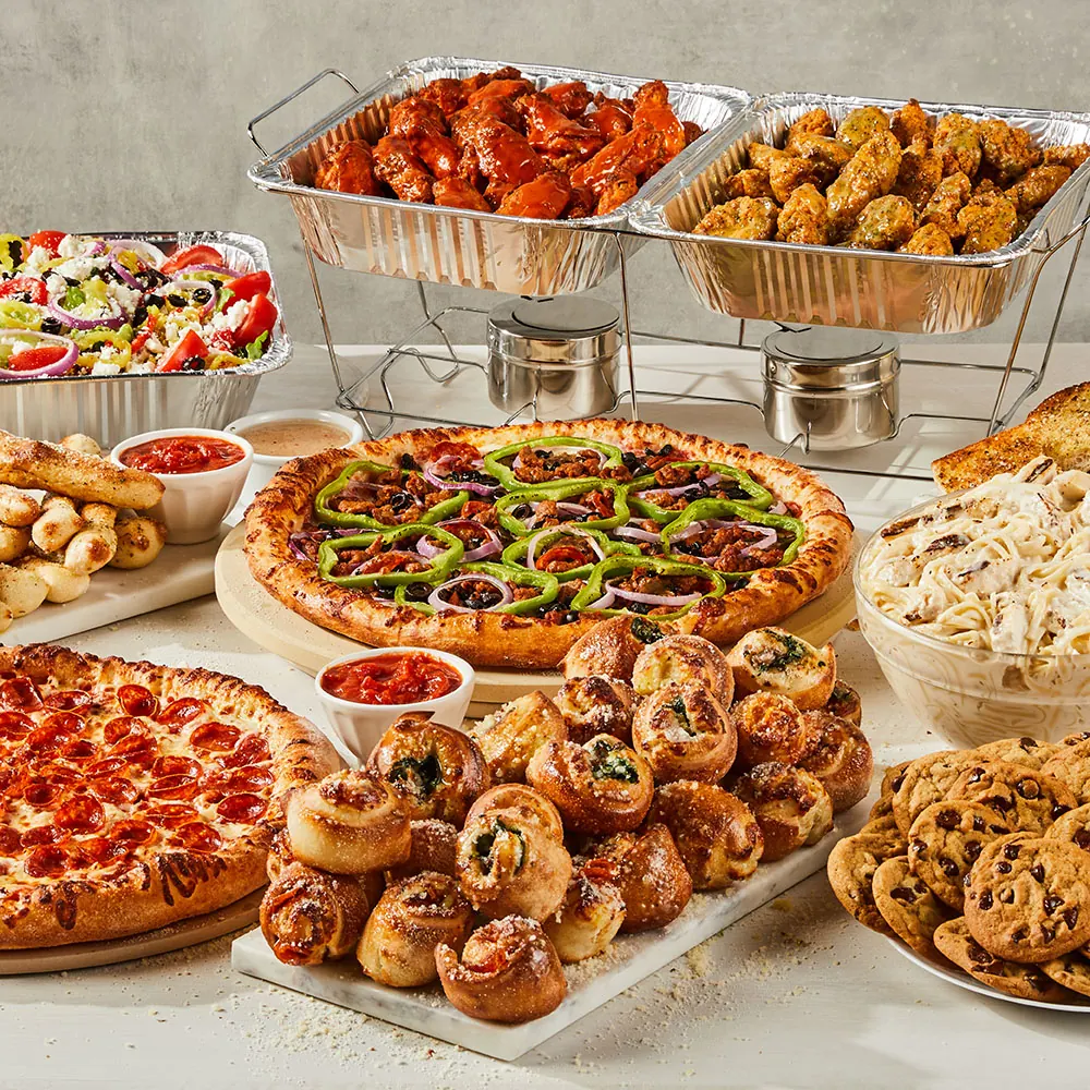 Vocelli Pizza catering spread with pizza, wings, rolls, salad and pasta